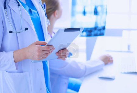 Foto de Sesión de cerca del médico con la tableta y colega con rayos X en el fondo - Imagen libre de derechos