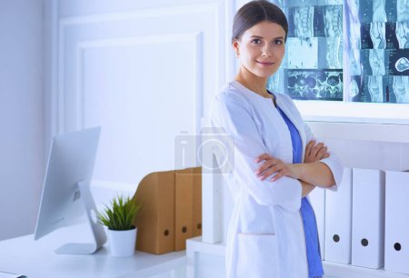 Foto de Retrato de una joven doctora con una bata blanca de pie en el hospital - Imagen libre de derechos