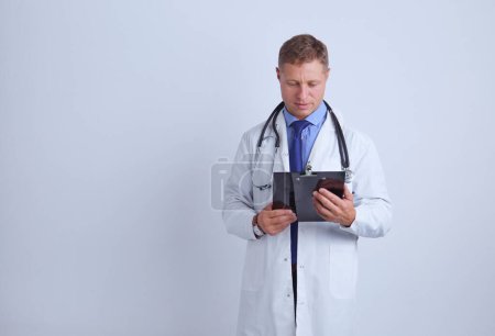 Téléchargez les photos : Médecin homme debout avec dossier, isolé sur fond blanc. - en image libre de droit