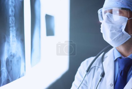 Photo for Young doctor looking X-Ray image on isolated white background. - Royalty Free Image