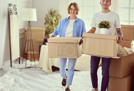 Photo for Couple holding boxes for moving the hands and looking inside box . - Royalty Free Image