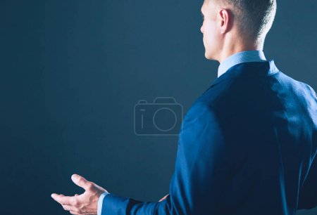 Foto de Retrato de un hombre de negocios de pie con un micrófono y mirando hacia el futuro, hablar en la conferencia
. - Imagen libre de derechos
