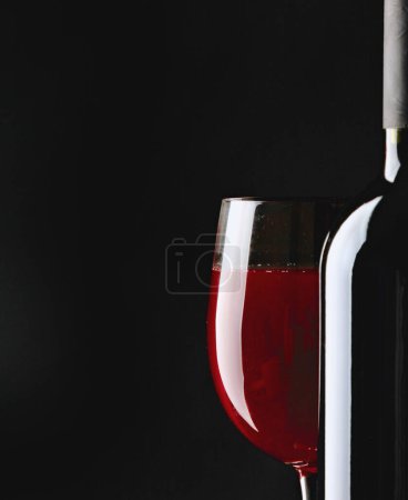 Foto de Silueta de botella y copa de vino sobre fondo negro. - Imagen libre de derechos