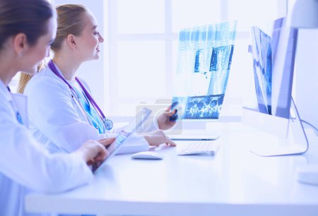 Téléchargez les photos : Femmes médecins regardant et discutant de l'image radiographique à l'hôpital - en image libre de droit