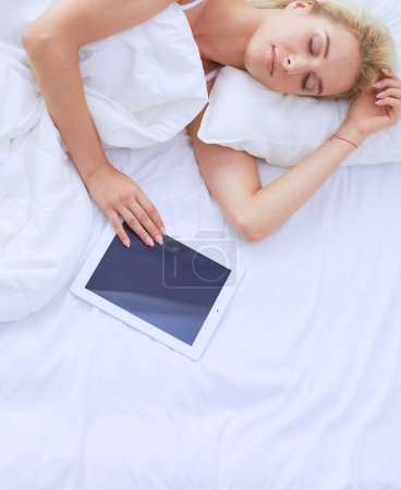 Photo for Girl holding digital tablet with blank screen and smiling at camera in bedroom. - Royalty Free Image