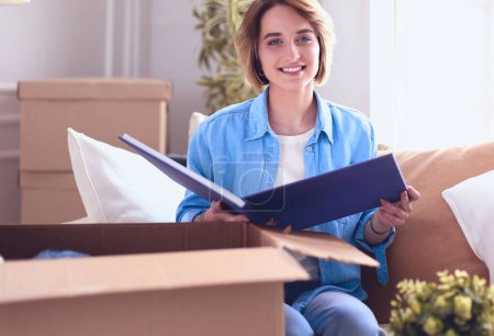 Photo for Young woman moving out and packing cardboard box. - Royalty Free Image