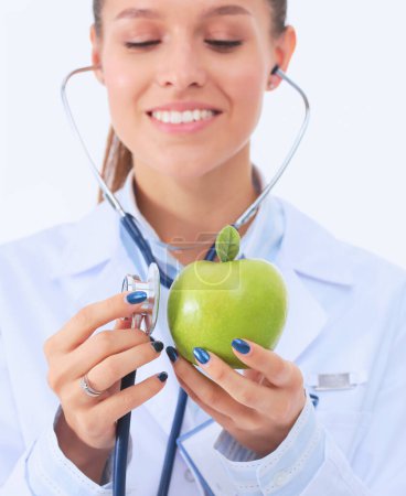 Téléchargez les photos : Médecin femme examinant pomme avec stéthoscope. Femmes médecins. - en image libre de droit