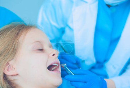 Téléchargez les photos : Petite fille assise dans le bureau des dentistes - en image libre de droit