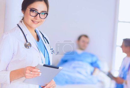 Téléchargez les photos : Médecin féminin utilisant une tablette dans le hall de l'hôpital, - en image libre de droit