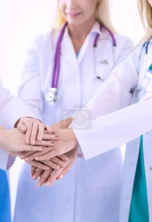 Foto de Médicos y enfermeras en un equipo médico apilándose las manos. - Imagen libre de derechos