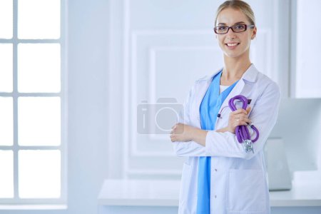 Téléchargez les photos : Joyeux médecin heureux avec les mains croisées sur fond bleu. - en image libre de droit