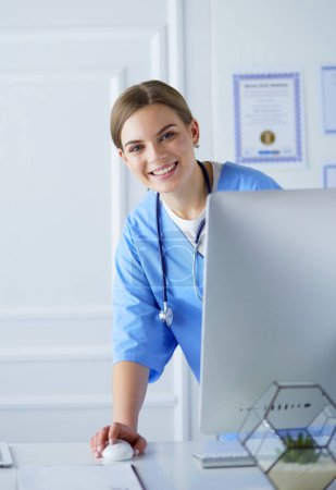 Téléchargez les photos : Jeune femme médecin au travail tout en tapant sur ordinateur portable dans le bureau de l'hôpital - en image libre de droit