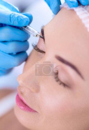 Photo for Permanent makeup for eyebrows. Closeup of beautiful woman with thick brows in beauty salon. - Royalty Free Image