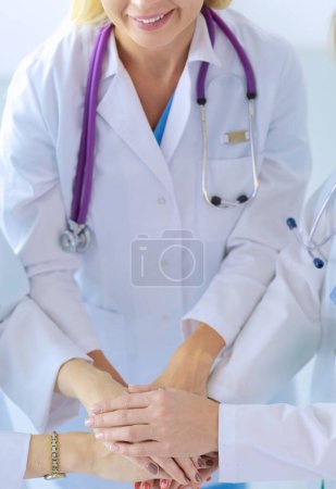 Foto de Médicos y enfermeras en un equipo médico apilándose las manos. - Imagen libre de derechos