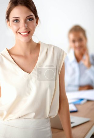 Téléchargez les photos : Attrayant femme d'affaires debout près du mur dans le bureau . - en image libre de droit