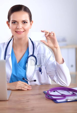 Photo for Beautiful young smiling female doctor sitting at the desk - Royalty Free Image