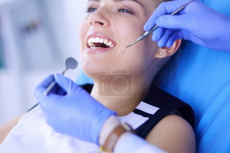 Photo for Young Female patient with open mouth examining dental inspection at dentist office - Royalty Free Image