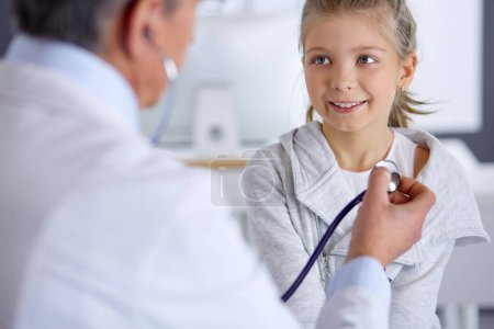 Photo for Girl and doctor with stethoscope listening to heartbeat. - Royalty Free Image