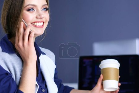 Téléchargez les photos : Jeune femme heureuse parlant sur un téléphone portable tout en étant assis avec une tasse de café. - en image libre de droit