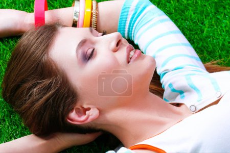 Téléchargez les photos : Belle jeune femme allongée sur l'herbe verte. - en image libre de droit