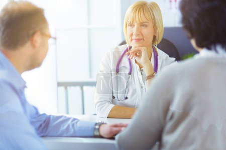 Photo for Attentive senior doctor listenint to patient in her office. - Royalty Free Image