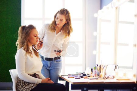 Téléchargez les photos : Maquilleuse faisant maquillage pour jeune belle mariée appliquant maquillage de mariage. - en image libre de droit