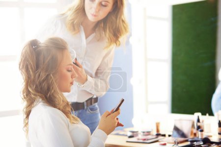 Photo for Make-up artist doing make up for young beautiful bride applying wedding make-up. - Royalty Free Image