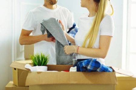 Photo for A just married couple unpacking boxes and moving into a new home. Positive emotion. - Royalty Free Image