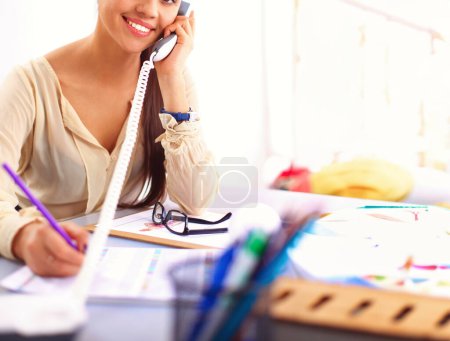 Photo for Young businesswoman sitting and talking on phone - Royalty Free Image