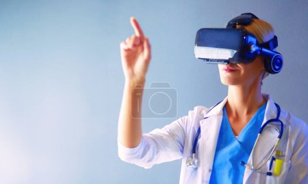 Téléchargez les photos : Médecin féminin portant des lunettes de réalité virtuelle isolées sur fond blanc. - en image libre de droit