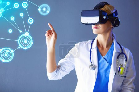 Téléchargez les photos : Médecin féminin portant des lunettes de réalité virtuelle isolées sur fond blanc. - en image libre de droit
