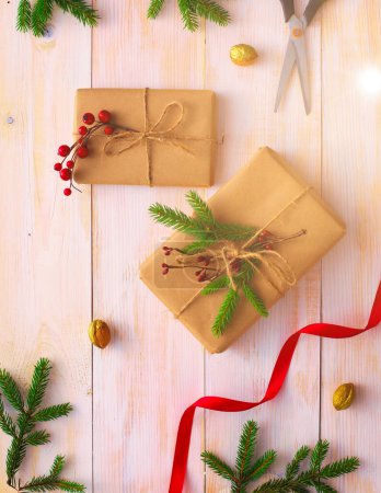 Foto de Cajas de regalo de Navidad y rama de abeto en la mesa de madera, puesta plana
, - Imagen libre de derechos