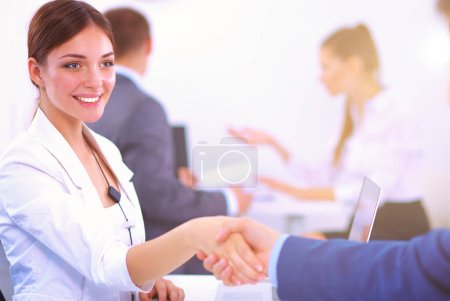 Photo for Business people shaking hands, finishing up a meeting, in office. - Royalty Free Image