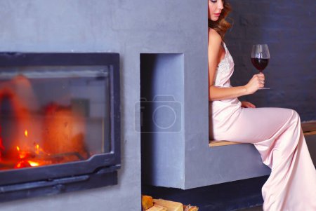 Téléchargez les photos : Femme sexy devant la cheminée. Foyer au bois - en image libre de droit