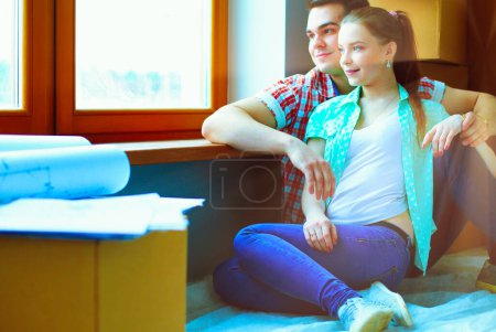 Photo for Couple moving in house sitting on the floor. Couple. - Royalty Free Image
