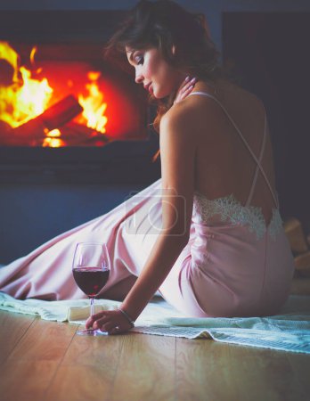 Photo for Sexy woman in front of the fireplace. Wood fireplace - Royalty Free Image