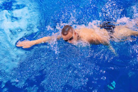 Téléchargez les photos : Nageur masculin à la piscine. Photo sous-marine. Nageur masculin - en image libre de droit