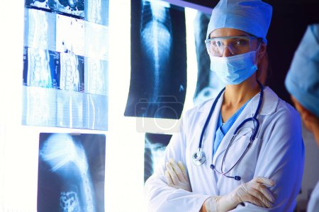 Téléchargez les photos : Image de femme séduisante médecin regardant les résultats des rayons X - en image libre de droit