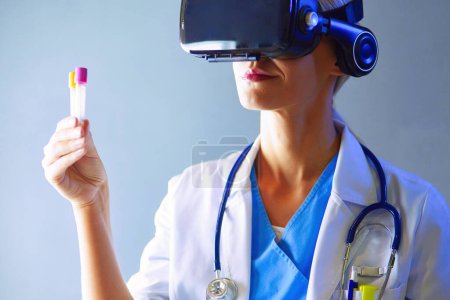 Téléchargez les photos : Médecin féminin portant des lunettes de réalité virtuelle isolées sur fond blanc - en image libre de droit