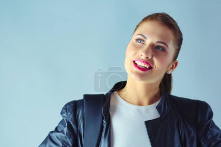 Téléchargez les photos : Portrait de belle jeune femme brune en veste noire élégante sur gris - en image libre de droit