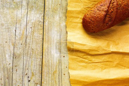 Photo for A loaf of Bread packed in paper on wooden table. - Royalty Free Image