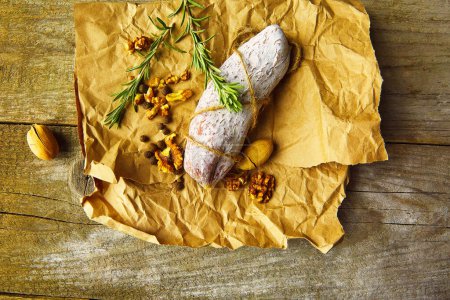 Téléchargez les photos : Salami italien avec sel de mer, romarin, ail et noix sur papier. Style rustique. Vue du dessus. - en image libre de droit