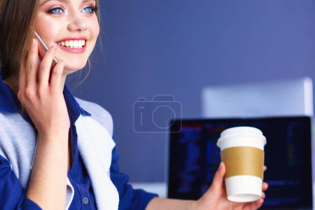 Téléchargez les photos : Jeune femme heureuse parlant sur un téléphone portable tout en étant assis avec une tasse de café. - en image libre de droit