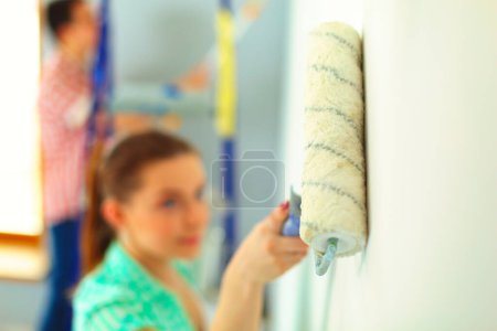 Photo for Portrait of happy smiling young couple painting interior wall of new house. - Royalty Free Image