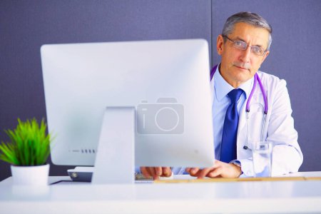 Foto de Retrato del médico senior sentado en el consultorio médico. - Imagen libre de derechos