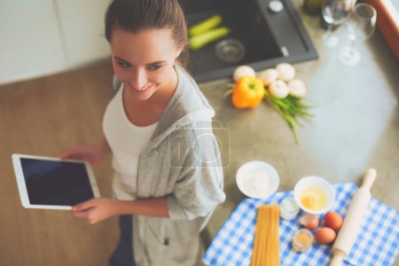 Téléchargez les photos : Jeune femme planification des dépenses et le paiement des factures sur sa cuisine - en image libre de droit