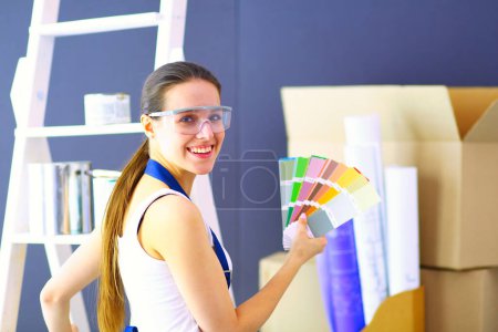 Photo for Happy beautiful young woman doing wall painting - Royalty Free Image