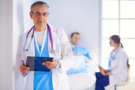 Photo for Doctor holding folder in front of a patient and a doctor. - Royalty Free Image
