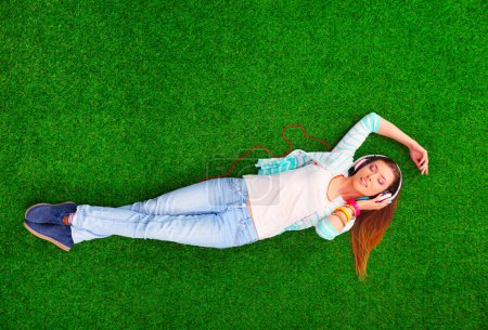 Téléchargez les photos : Belle jeune femme allongée sur l'herbe verte. - en image libre de droit