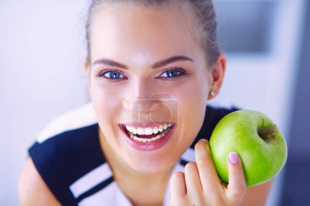 Téléchargez les photos : Portrait rapproché d'une femme souriante et en bonne santé à la pomme verte - en image libre de droit